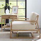 Living room scene with Retreat Pole Rattan End Table, armchair, cabinet, and hanging rattan light fixture by floor-to-ceil...