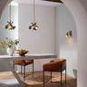 Two russet leather bar stools at marble dining table in bright minimalist room with archway