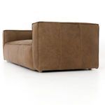 Nolita Reverse Stitch Sofa styled in a modern living room featuring black armchairs, glass coffee table, and monochrome de...