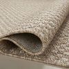 Close-up of rug folded to reveal thick woven polypropylene fabric and backing texture.