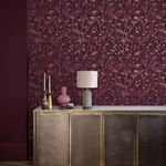 Wallpaper installed on wall above brass and marble sideboard with lamp and decorative objects