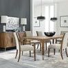 Dining room setting with Chapman Upholstered Chairs featuring armchairs at table ends and pendant lights overhead