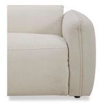 Close-up showing plush cushion and fabric seam along sofa arm and seat junction