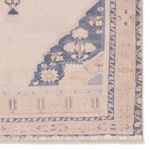 Detailed corner close-up highlighting floral and geometric patterns in tan and blue tones