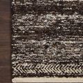Close-up of Reyla Mocha / Ivory rug corner on dark wood floor highlighting texture and herringbone border
