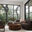 Left-facing sectional in modern living room with large black-framed windows and wood coffee table.