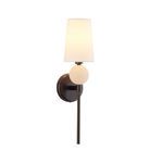 Sconce illuminated with warm light glowing from linen shade