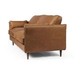 Side view showing smooth leather back and almond tapering legs of the sofa
