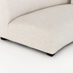 Close angled view of sofa arm and base showcasing fabric texture and small dark feet