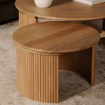 Close-up showing paired set with smaller round side table featuring matching design and finish