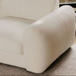 Detail of rounded, plush arm of Berga sectional with visible fabric texture on rug