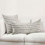 Living room setting with Linna Throw Pillow paired with a matching square pillow on white couch