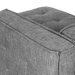Close-up of armrest corner with visible tufting and sharp piping seam