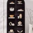 Styled Breya cabinet filled with neutral ceramics and decor next to sculptural vase