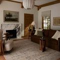 Milena rug styled in a living room featuring brown couch, armchair, and warm wooden accents