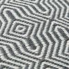 Close-up showing textured woven charcoal and white geometric pattern on pillow surface
