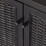 Close-up of cylindrical black metal door knobs centered on cane doors.