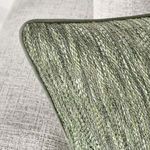 Close-up angled view of pillow corner showing woven texture and muted green accents against grey sofa