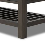 Close-up detail of slatted lower shelf corner and console leg showing solid oak construction