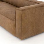Detail of sofa armrest showing top-grain leather surface and reverse stitched welt.