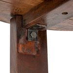 Close-up of metal bracket attaching cross-leg base to tabletop underside