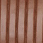 Close-up of chestnut leather vertical channels on the backrest upholstery