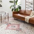 Skye Ivory / Berry Rug styled in living room under brown leather sofa, side chair, and green plant