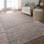 Rug styled in modern room with white armchair, wooden side table, and natural light