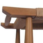 Underside view highlighting woven wicker seat and rounded teak framework