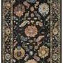 Black wool rug with thick pile featuring asymmetrical floral and paisley patterns in multicolor tones