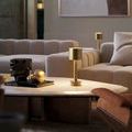Traverse Lamp styled on round coffee table in living room with neutral sofas and decorative objects