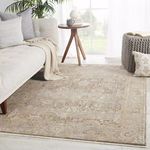 Rug styled in a bright living room with light gray sofa, wooden side table, and natural light