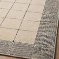 Partial angled view of Francis rug showing the texture of its hand-hooked wool and monochrome tile-inspired design