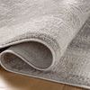 Rolled corner detail emphasizing rug texture and soft pile on hardwood floor