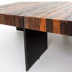 Side close-up showing Alec Coffee Table's floating wood top and angular black iron support detail