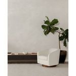 Oscy swivel chair positioned near indoor fiddle leaf fig plant on beige carpet