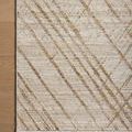 corner of rug on wood floor highlighting fringed edges and linear gold pattern