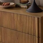 Close-up of dresser top with decorative lamp and a bowl showing textured wood finish