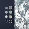Side-by-side view of Perrow Wallpaper next to various blue and gray paint samples on wall