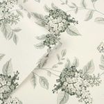 Rolled wallpaper showing texture and smooth finish with floral design of lilac stems and leaves