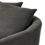 Close-up showing top curve of chair's rounded back and two soft fabric throw pillows