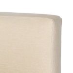 Close-up of cream linen slipcovered headboard stitching and corner detail