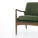 Partial front angle of chair focusing on padded seat cushion and linear wood frame