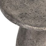 Macro view highlighting the rough texture and subtle gleam of the table's concrete finish