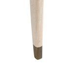 Close-up of the tapered oak leg featuring a bronze cap at the base of the Lanna desk.
