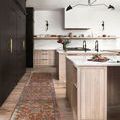 Runner rug with terracotta base and floral motifs in muted blue, cream, and mauve in a modern kitchen setting