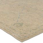 Repeated close-up of tan and blue hand-knotted wool rug corner showing hand-sheared texture and finished edge