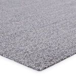 Close-up of rug corner showing tight weave and finished edge in black and white yarns