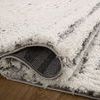 Rolled edge showing plush pile and textured backing of the rug