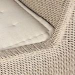 Tight close-up of cushioned seat edge with woven rattan behind